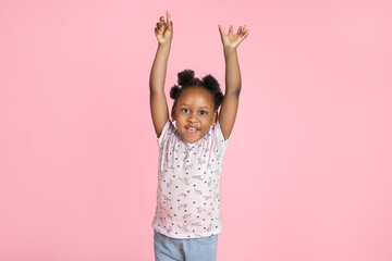 Emotions, childhood and people concept. Close up of happy little african american girl with arms...