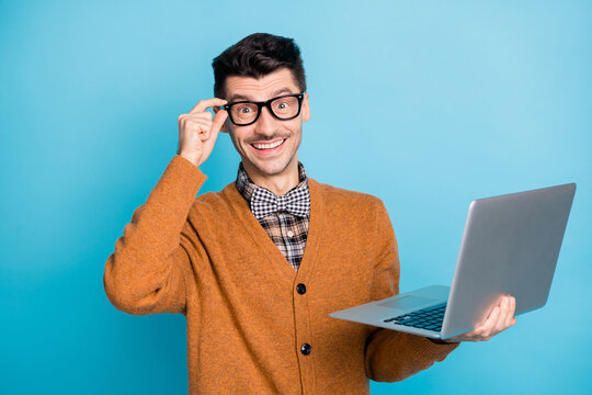 Photo of cheerful attractive young man hold hand laptop glasses amazed isolated on blue color background