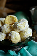 Russian tea cookies on a rustic plateau against a green background