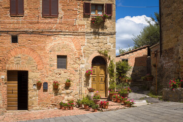 Fototapeta na wymiar Beautiful medieval houses adorned with flowers, Montichiello, Italy
