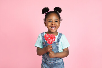 Happiness, childhood, kid and sweets. Cute pretty little African girl child, posing to camera with...