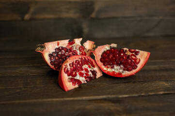 The pomegranate slices lie on a dark background.