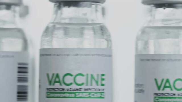 Looped. Flacons of vaccine for COVID-19 coronavirus cure are quickly rotated in research lab. Vaccination, injection, clinical trial during pandemic. Bottles are spinning clockwise. Closeup macro