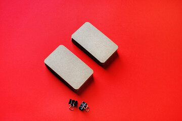 Photo of blank kraft business cards stacks on red paper background. Template for branding identity.