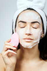 woman using electric cleansing brush for face deep cleaning . Beautiful woman clean face with...