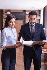 Multiethnic business people working with papers in restaurant