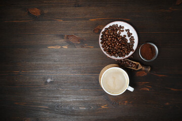 Obraz na płótnie Canvas Coffee cup, coffee beans and ground powder on wooden background. Copy space for your text. Top view. Flat lay.