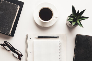 Office desk table with supplies, coffee cup and flower. Top view