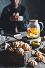 Woman is sitting with Hot tea with fresh grapefruit on wooden tablet. Healthy drink, Eco, vegan.