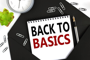 Back to basics. text on a sheet of notepad on a black envelope on a light background