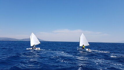 Children sailing with optimist boats - obrazy, fototapety, plakaty