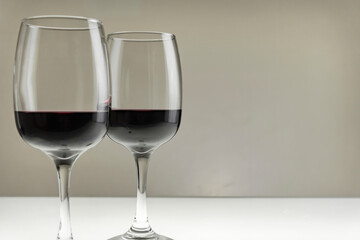 Two large glasses with red wine on a blurred background, close-up.Horizontal photo