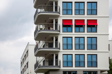 Drei rote Markisen an einer Fassade