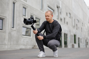 videography, filmmaking and creativity concept - professional male videographer shooting video...
