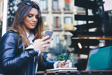 Young woman chatting with friends using smartphone