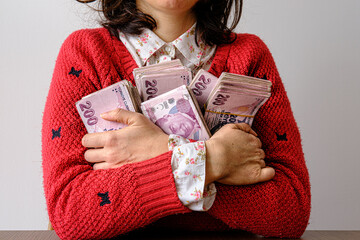 Young woman hugging piles of banknotes. Victory and richness concept photo. Happy, glad and selfish...