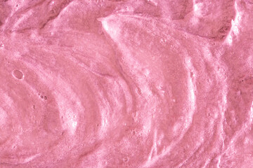 Fototapeta na wymiar Pink cream texture. The surface of berry yogurt and a smoothie of whipped cream. Background texture of masks and scrubs for face and body. Pearlescent silver surface of pink foam.