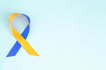 World Down Syndrome Day. Yellow and blue ribbon on blue background with copy space. 21 March