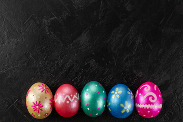Easter eggs trendy colored classic deep blue, green, orange, magenta and golden decorated on black background. Happy Easter card with copy space for text. Minimal style.