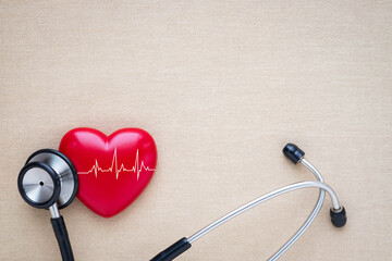 Black stethoscope, red heart with cardiogram for check-up on table background. Stethoscope equipment of doctor medical use to diagnose heartbeat. World heart day. health care and cardiology concept.