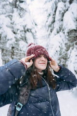 Fototapeta na wymiar Young happy girl is enjoying the winter on a frosty day, with snow in winter Park.The winter lifestyle.Individual winter adventures.Rest during the Christmas holidays.healthy break