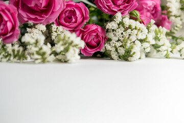 white dried flowers statice and rose raspberry peony on a white background . space for text