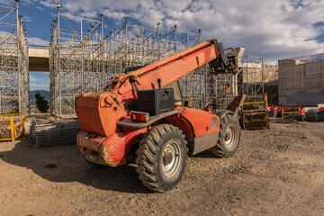 Forklift on a construction site, preparing to raise construction parts