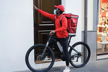 African delivery man with electric bike ringing the doorbell - Focus on face