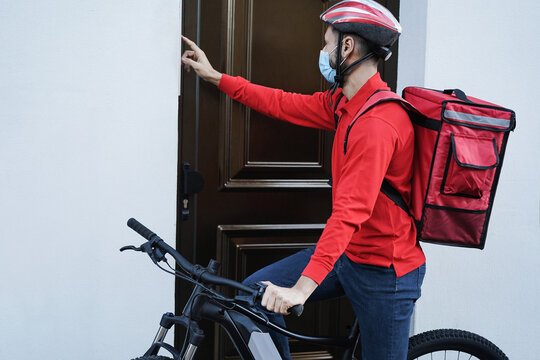 Delivery Man With Electric Bike Ringing The Doorbell - Focus On Face