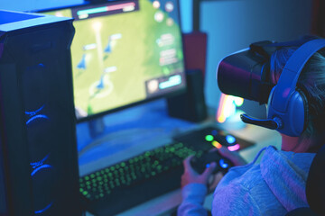 Girl gamer playing strategy game online using vr virtual reality headset - Focus on headphones