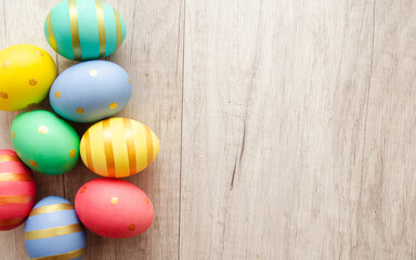 Fototapeta na wymiar Colorful handmade painted easter eggs on a wood background.