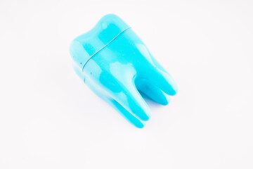 plastic toy tooth on white background