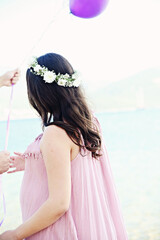 A pregnant, elegant woman from her back