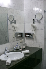 Modern bathroom interior with sink, mirror and hairdryer, vertical orientation