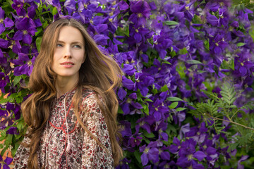 Beautiful woman with long hair in spring purple flowers background