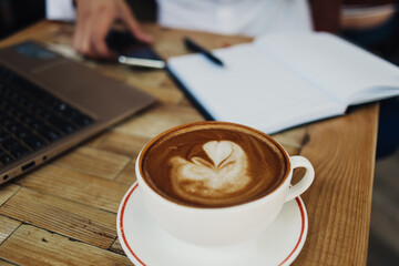 Freelancer working in cafe with cup of coffee