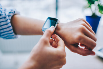 Crop faceless woman using smartwatch on wrist