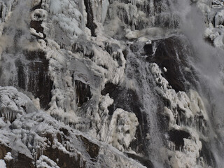 Fototapeta na wymiar Closeup view of waterfalls Todtnauer Wasserfälle in winter season with bizarre ice formations on the rocks with a lot of icicles on sunny day near Todtnau, Germany in the Black Forest hills.