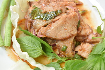 spicy roasted pork Thai salad eat with fresh basil leaf and cabbage on plate
