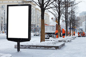 Vertical billboard on the city sidewalk in winter, workers are cleaning the city from snow. Mock-up.