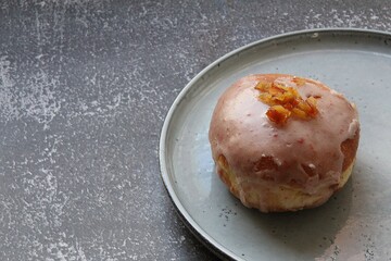 fresh donut topped with icing and sprinkled with orange peel, fried biscuit, dessert for a fat Thursday