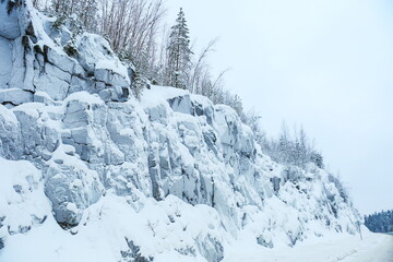 Fototapeta na wymiar rocky hill with trees in winter frost 
