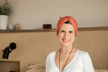 Portrait of caucasian smiling woman with home clothes, turban, hippie indian style, looking at camera. Happy Healthy vegan young mother on her 30s, in peace, confident, self-convinced. close-up.