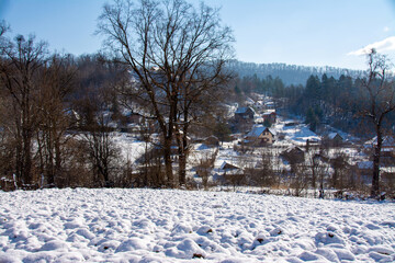 a plowed field near a village in winter
