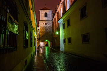 night old city narrow street in the town with colourful evening lights and pink sky 