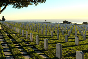 Sunset view of Fort Rosecrans National Cemetery overlooking the Pacific Ocean; back facing tombstones; Point Loma, San Diego, California