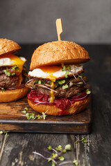 Junk food - homemade beef burgers on vintage wooden background