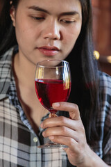 Asian woman drinking from a wine glass