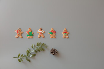 Gingerbread cookies, green sprig, cones on a gray background. Concept for christmas, new year 2022, winter. Have place for text