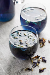 Cups of butterfly pea flower tea with  on grey background. Healthy concept